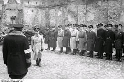 Szeryński (stojący tyłem) odbiera meldunek Jakuba Lejkina, maj 1941